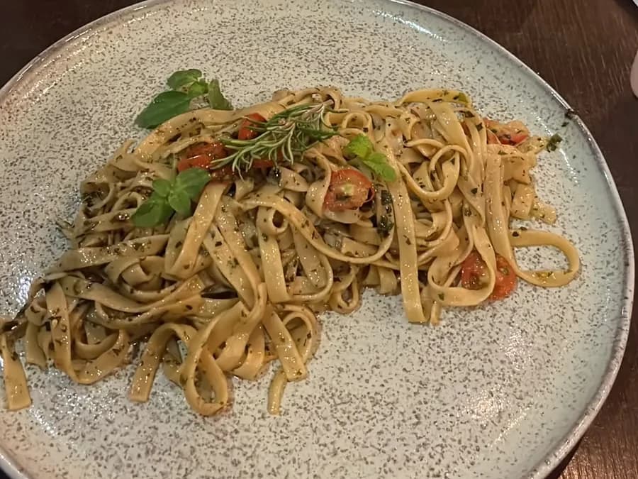 Massa artesanal da casa, finalizada com tomate e ervas frescas